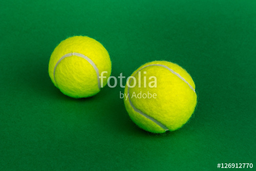 two tennis balls on a green background two tennis balls on a green background